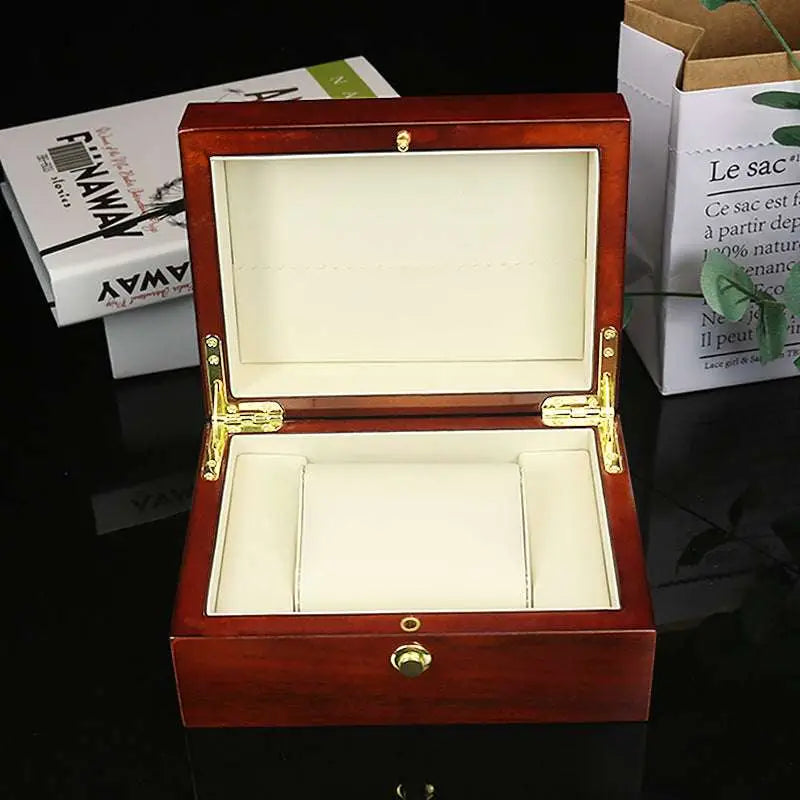 Polished reddish brown wooden watch box custom with gold hardware and cream-colored interior for jewelry storage