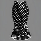 Black and white polka dot midi dress with slim fit fishtail skirt, fitted bodice, three front buttons, and ruffled hem