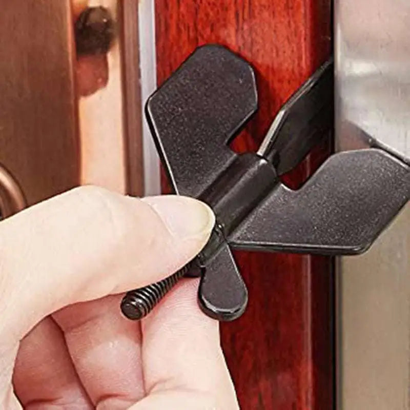 Portable black plastic winged door lock stopper with screw for securing doors as a portable door lock stopper