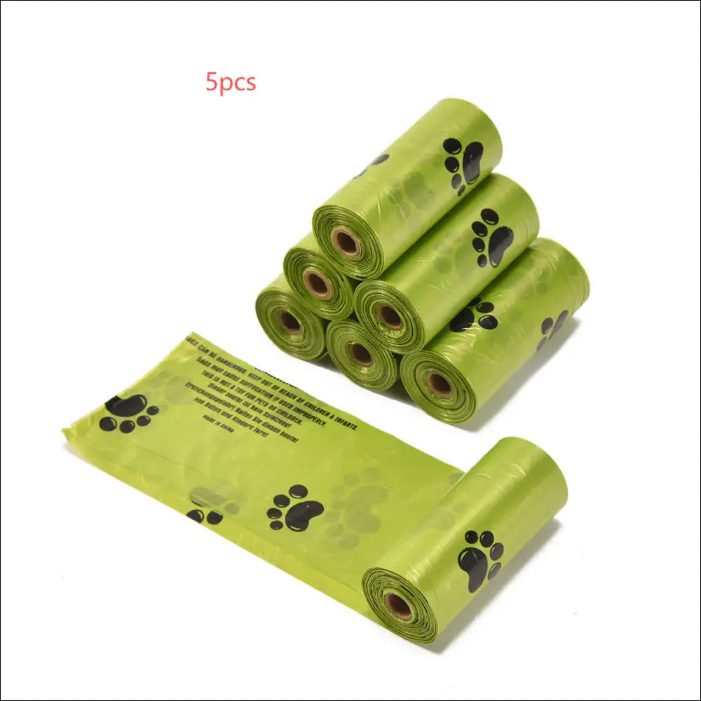 Green plastic dog poop bags with black paw prints in a portable poop bag dispenser for easy waste cleanup