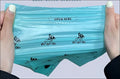 Teal plastic poop bag with black dog logo and pet go go branding in a portable dog poop scooper dispenser