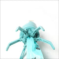 Teal plastic portable dog poop scooper with four extendable legs and central poop bag dispenser holding a matching poop bag