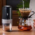 Black and silver portable electric ceramic coffee grinder with usb charging capability and textured metallic band detail