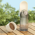 Transparent glass coffee grinder with ribbed design and off-white lid alongside portable green dog walking pet water cup
