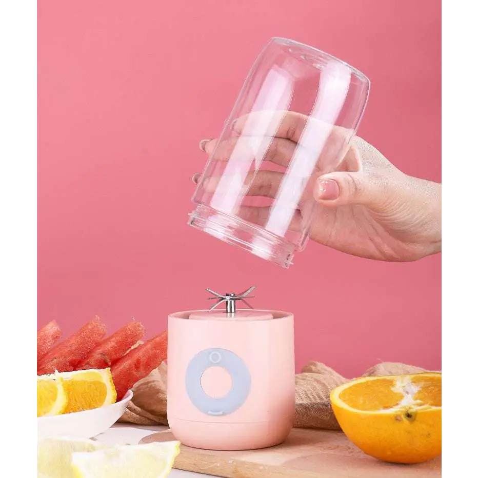 Three portable usb automatic mini juicer cups with clear glass jars and pastel silicone bases in white pink and mint green