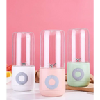 Three portable usb automatic mini juicer cups with clear glass jars and pastel silicone bases in white pink and mint green