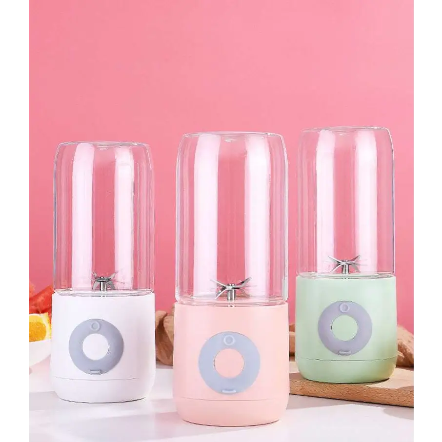 Three portable usb automatic mini juicer cups with clear glass jars and pastel silicone bases in white pink and mint green