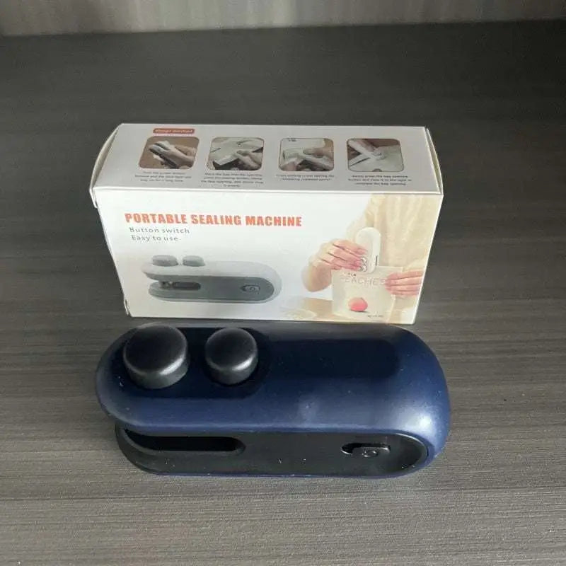 Blue portable usb heat sealer with two black circular buttons and magnetic storage clip in a compact design