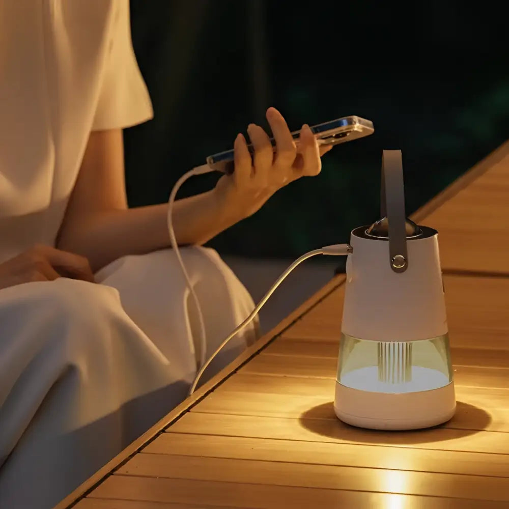 White cylindrical projection mosquito repellent night light lantern with transparent glass base and top handle emitting warm light