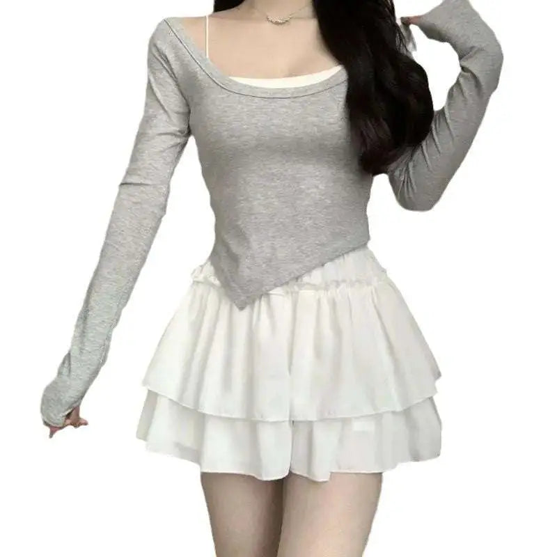 Gray long-sleeved top with square neckline and asymmetrical hem layered over white camisole with pure desire style slimming ballet skirt