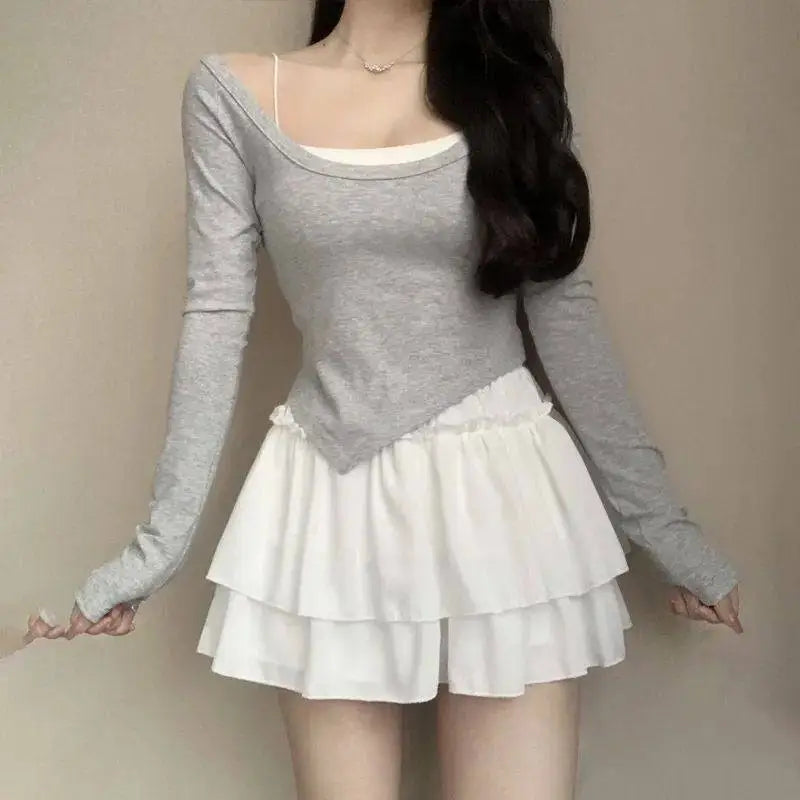 Gray long-sleeved top with square neckline and asymmetrical hem worn over white camisole with pure desire style slimming ballet skirt