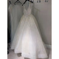 A pure white sequined wedding evening dress with a deep v-neckline and delicate spaghetti straps