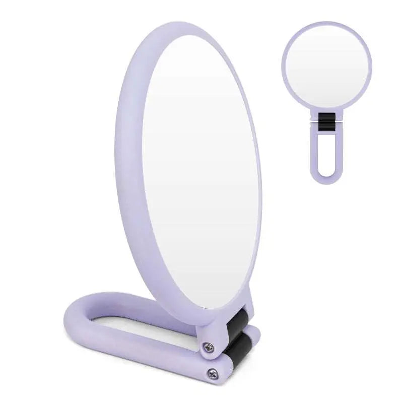 Lavender-colored foldable handle mirror with 10x magnification and sleek black hinge accents for precise makeup application