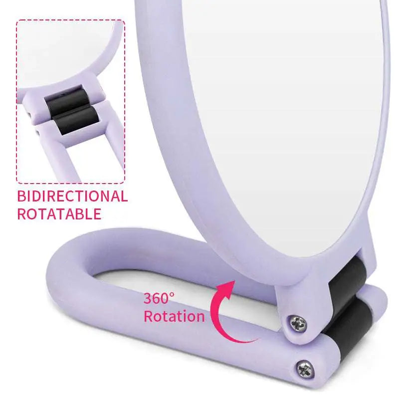 Lavender-colored foldable handle mirror with 10x magnification features a 360-degree rotating base and bidirectional hinge