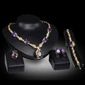 Gold-toned purple amethyst united states fashion jewelry set with oval-cut stones and clear crystals on black mannequins