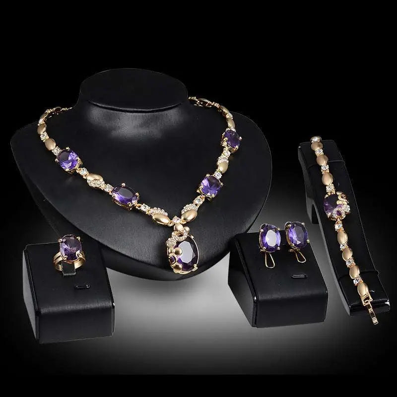 Gold-toned purple amethyst united states fashion jewelry set with oval-cut stones and clear crystals on black mannequins