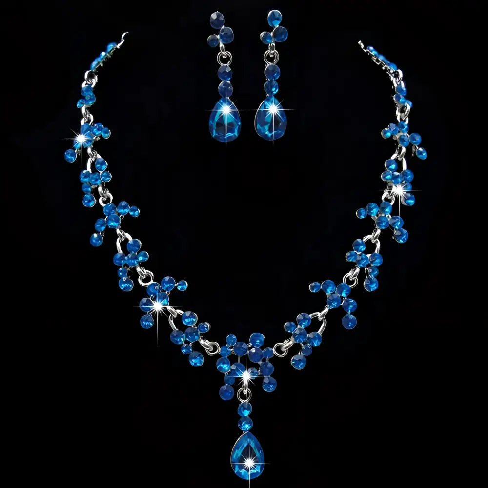A sparkling blue crystal wedding jewelry necklace and teardrop earrings set with silver metalwork and faceted stones