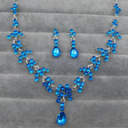 A sparkling blue crystal wedding jewelry necklace and earring set with silver chain and intricate floral designs