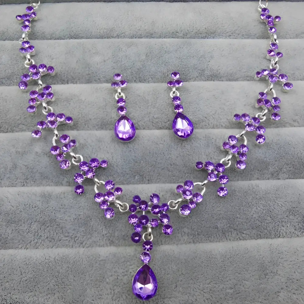 Purple crystal wedding jewelry necklace and earring set with silver-toned metalwork and cascading teardrop stones