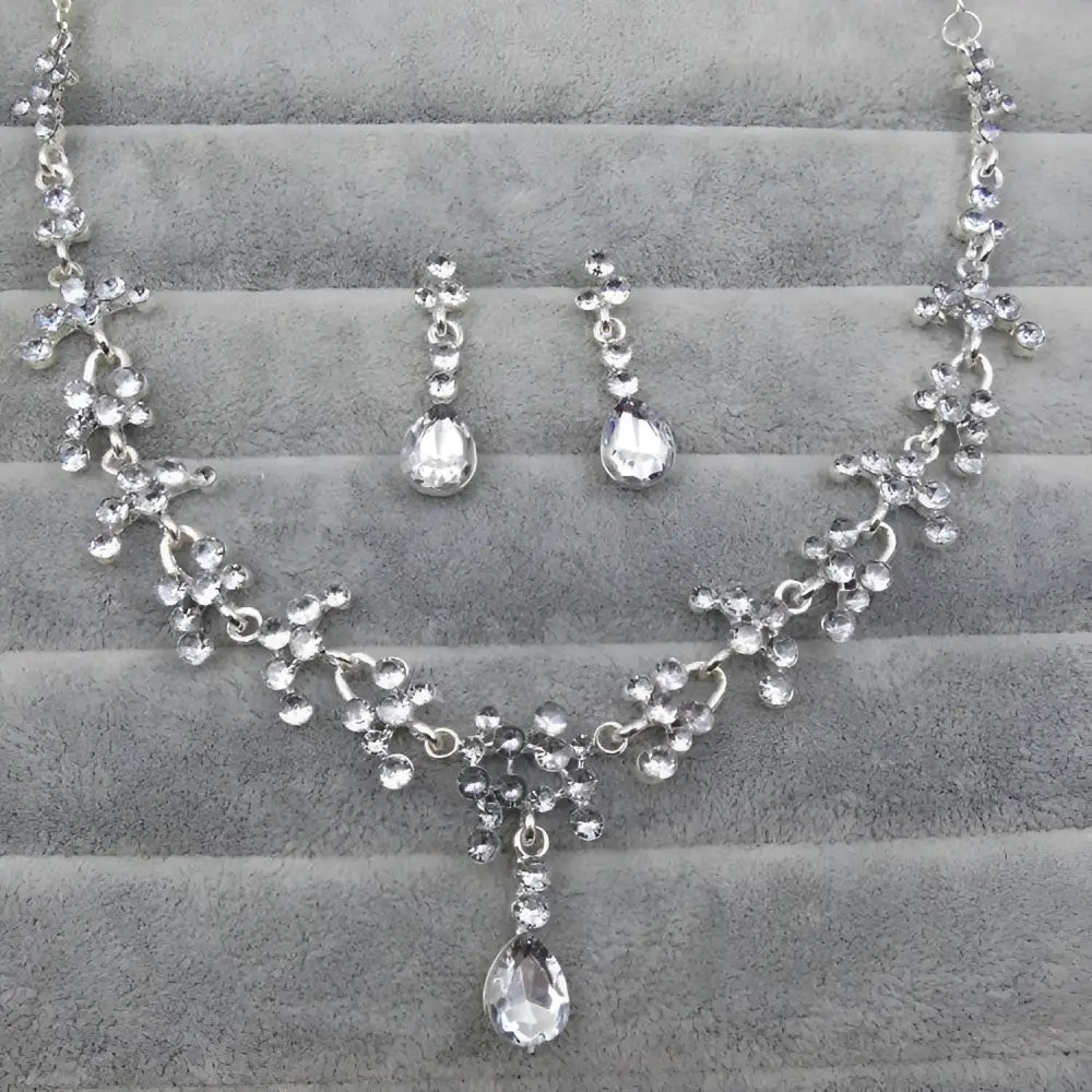 Purple crystal wedding jewelry necklace and earring set with silver-toned metalwork and cascading teardrop stones