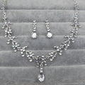 Silver-toned crystal wedding jewelry necklace and earring set with dangling purple crystal teardrop pendants for weddings