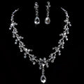 A sparkling silver purple crystal wedding necklace and earring set with floral design and clear crystal accents