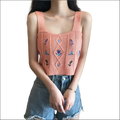 A peach knitted embroidered floral camisole with blue floral embroidery and diamond cable knit design