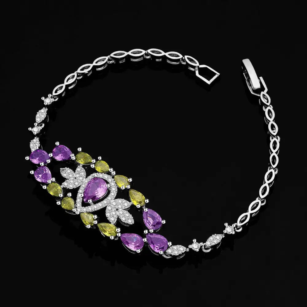 A silver-toned bracelet with purple floral color zirconium gemstones matching the necklace earrings set
