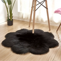 Black fluffy sheepskin style rug with soft plush texture in an organic purple floral shape artificial woolen carpet design