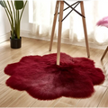 A plush deep red floral shape artificial woolen carpet rug with a soft fluffy texture and petal-like design