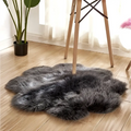 A plush dark gray artificial woolen carpet rug with a soft texture and irregular floral shape for home decor