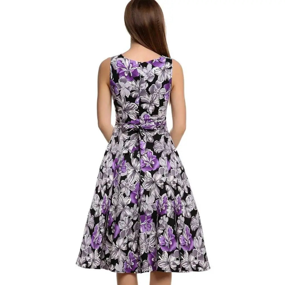 A sleeveless vintage print black dress with purple floral and silver accents featuring a fitted bodice and flared skirt