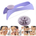 Purple manual cotton hair remover tool made of plastic with a circular handle and adjustable guide to remove facial hair