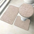 Beige pebble-textured three piece bathroom rug set including toilet lid cover in the purple pebble collection