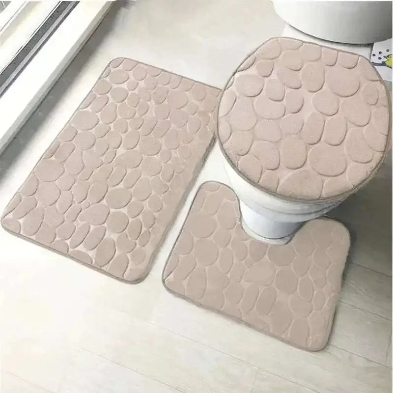 Beige pebble-textured three piece bathroom rug set including toilet lid cover in the purple pebble collection