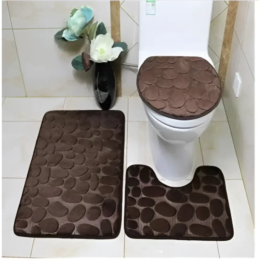 Brown pebble-textured bathroom rug set featuring a toilet lid cover from the purple pebble 3 piece collection