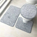 Gray pebble-textured bathroom rug set featuring a toilet lid cover from the purple pebble 3 piece collection