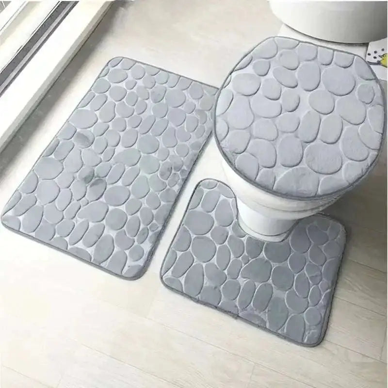 Gray pebble-textured bathroom rug set featuring a toilet lid cover from the purple pebble 3 piece collection