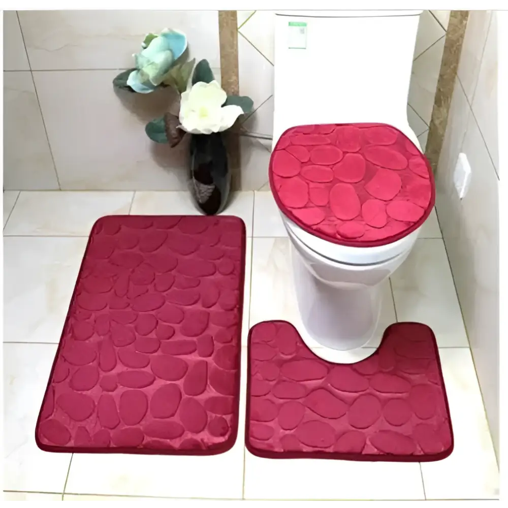 Set of three red pebble textured bathroom rug set with matching toilet lid cover for coordinated bathroom decor