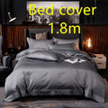 Dark gray satin bed cover with subtle sheen and embroidered logo at foot in purple satin embroidered four-piece set fabric main component