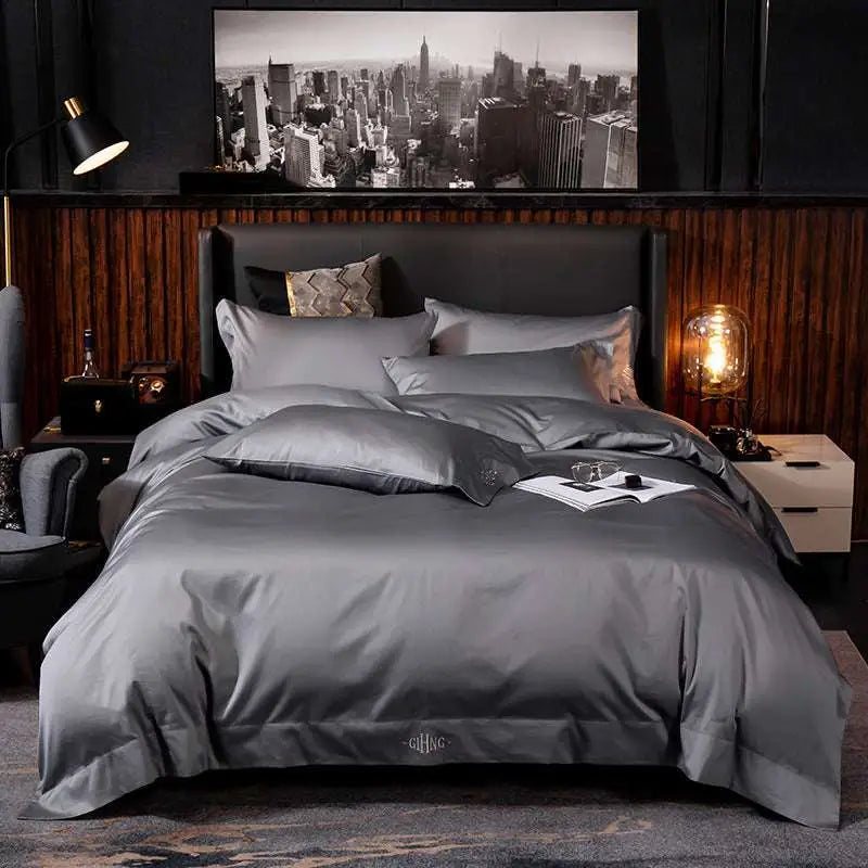 Dark gray satin embroidered four-piece bed sheet set with subtle embroidered logo on fabric main component at duvet foot