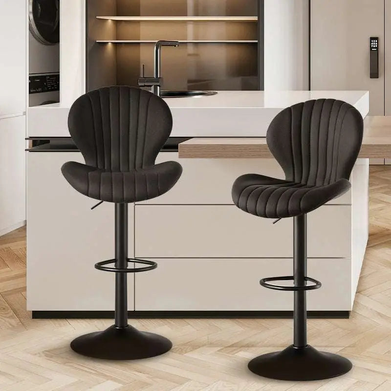 Black upholstered bar stools with vertical stitching and sleek metal bases complement quilted cream velvet luxury womens fashion