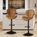 Tan quilted leather bar stools with black metal bases and footrests complement luxury women’s fashion interiors