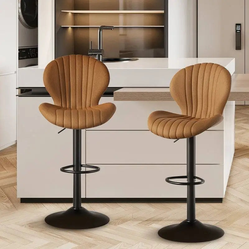 Tan quilted leather bar stools with black metal bases and footrests complement luxury women’s fashion interiors