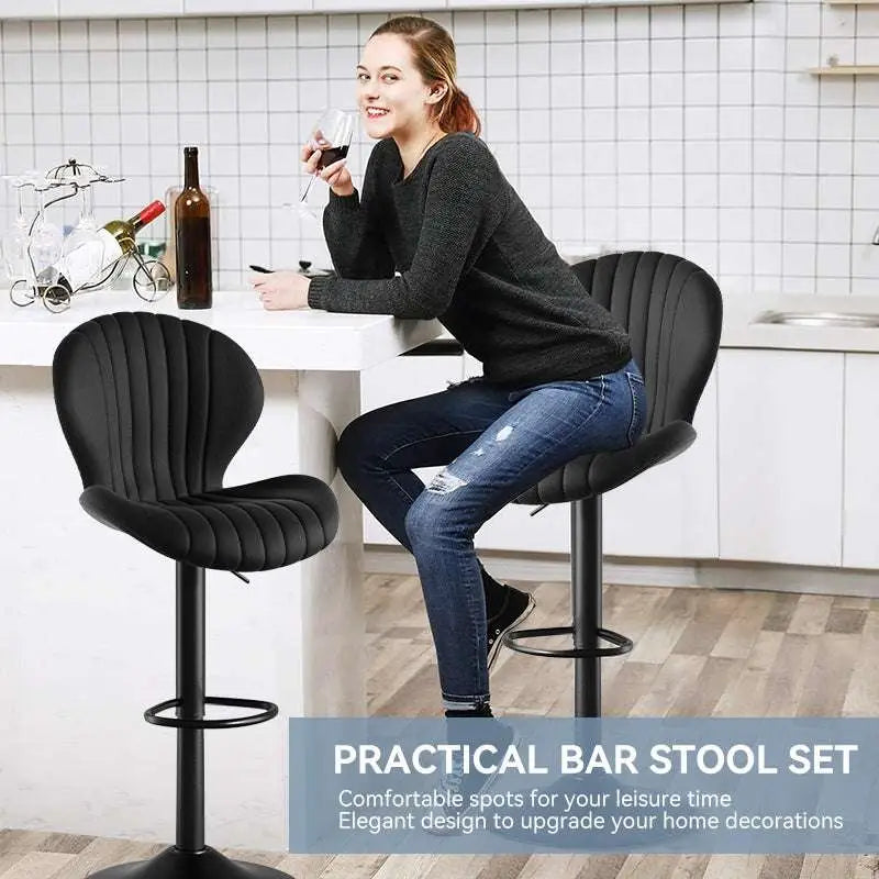 Quilted cream velvet upholstered bar stools with black metal bases and footrests for luxury women’s fashion seating