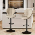 Quilted cream velvet upholstered bar stools with black metal bases and footrests for luxury women’s fashion seating