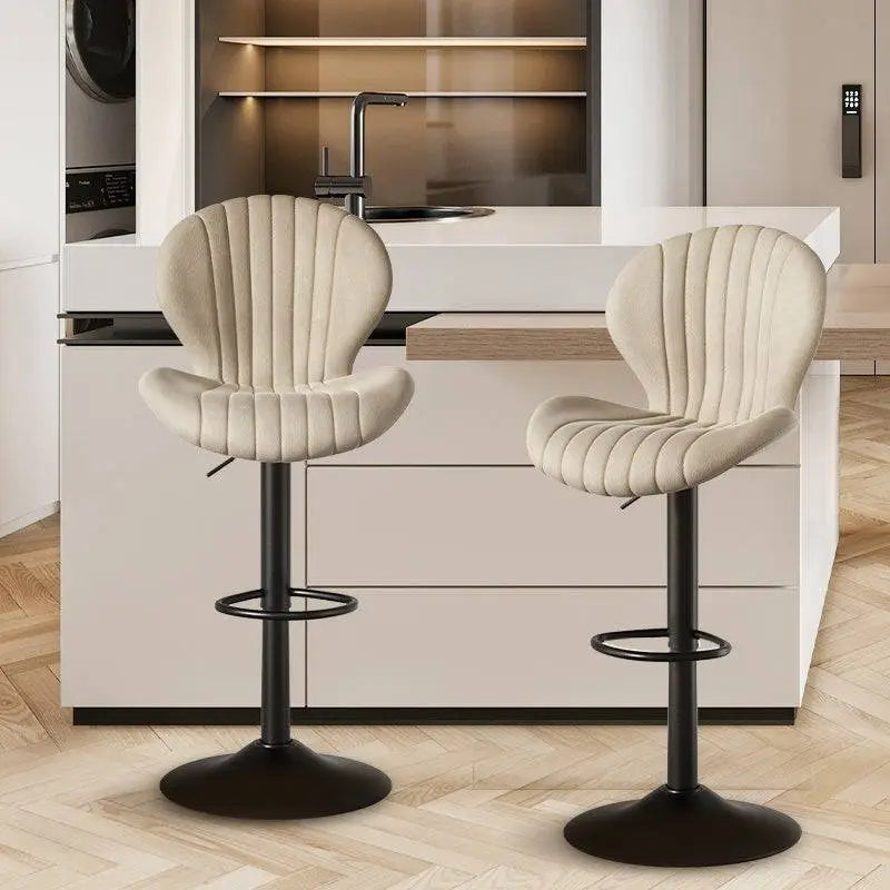 Quilted cream velvet upholstered bar stools with black metal bases and footrests for luxury women’s fashion seating