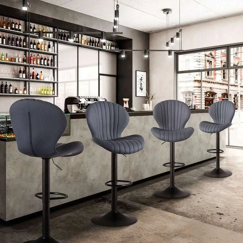 Modern gray upholstered bar stools with sleek black metal bases and adjustable height for luxury women’s fashion settings