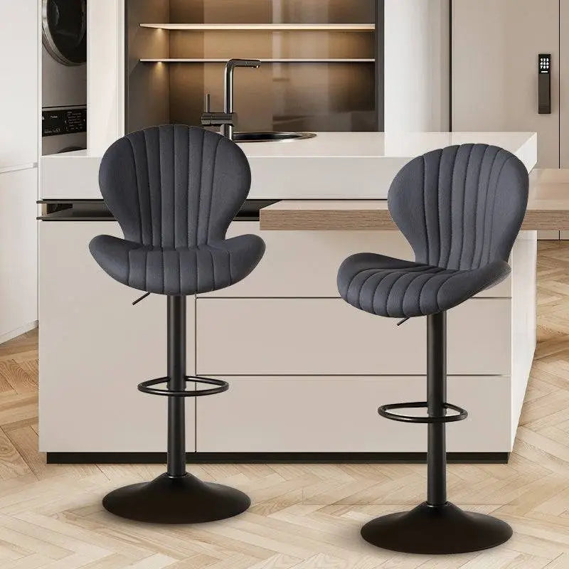 Two sleek dark gray upholstered bar stools with vertical stitching and black metal bases for luxury womens fashion