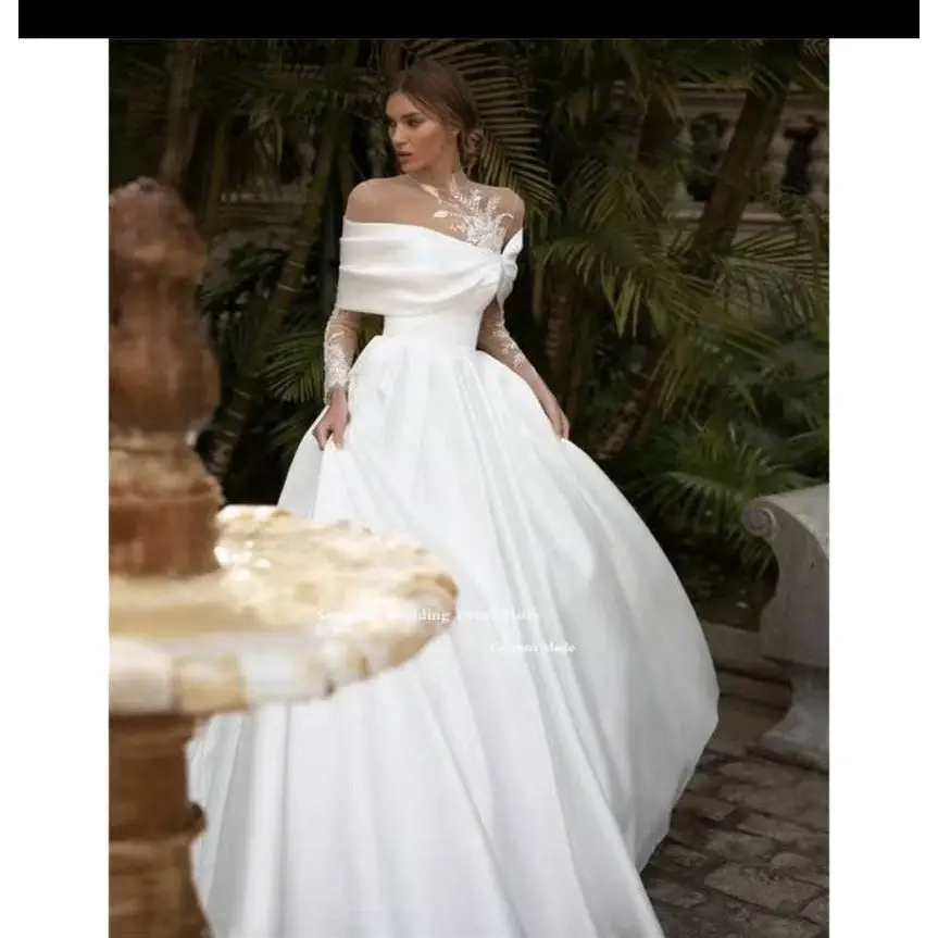 A flowing white tutu wedding dress with raglan sleeve long sheer sleeves and intricate lace bodice detailing